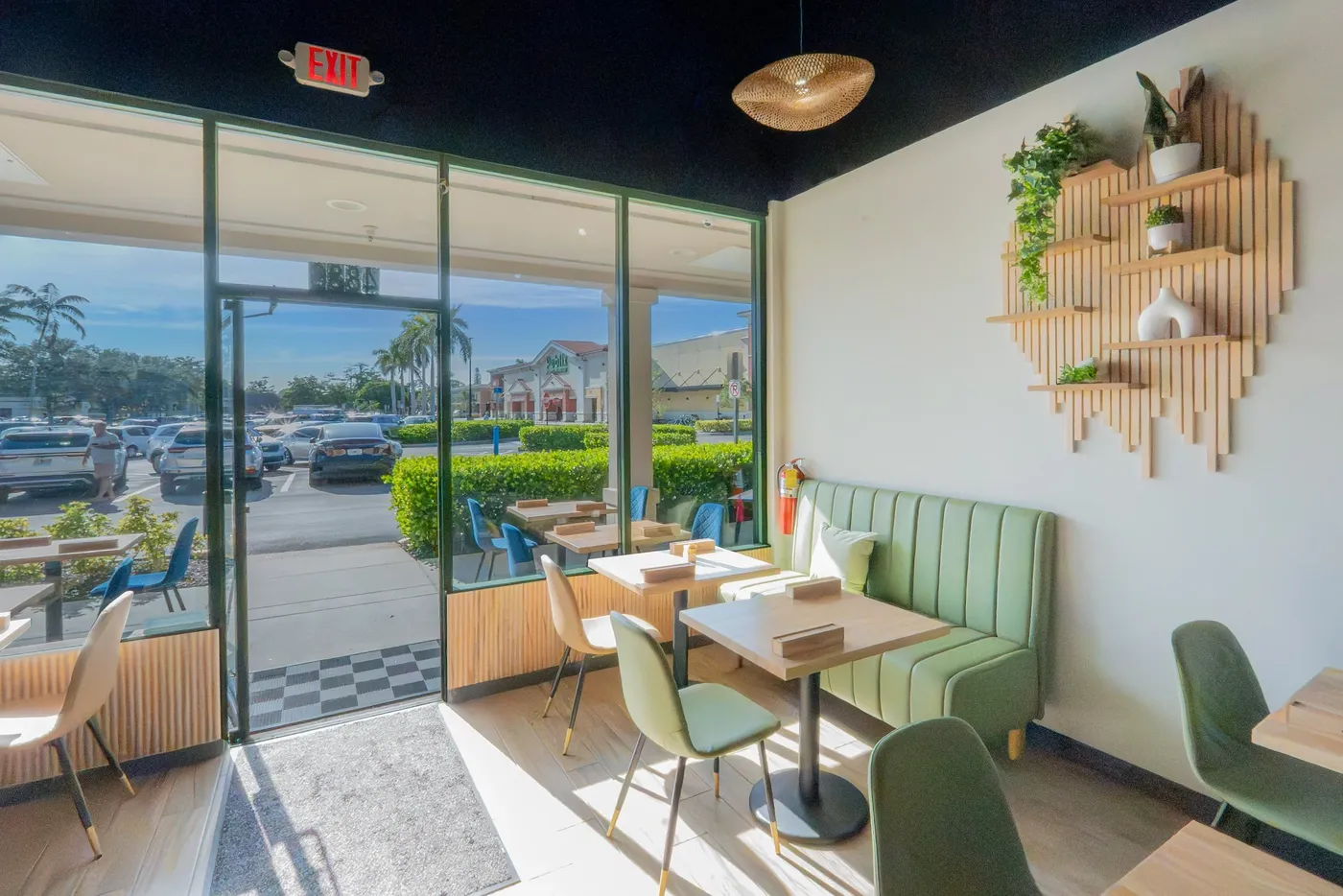 Bright Cafe Seabreeze dining room with sage booths and plants